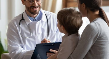 Doctor talking to caregiver and pediatric patient