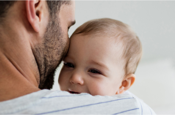 Baby resting head on man's shoulder